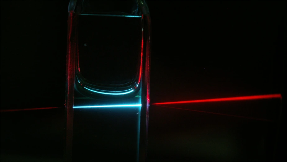 Die organischen Moleküle (hier in einer Kuvette) wandeln niedrigenergetische (rote) Photonen in höherenergetische („blaue“) Photonen um, die in einer Solarzelle zur Stromerzeugung beitragen können. Bild: Y. Y. Cheng/UNSW