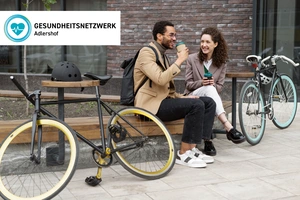 Zwei Menschen mit ihren Fahrrädern auf einer Bank