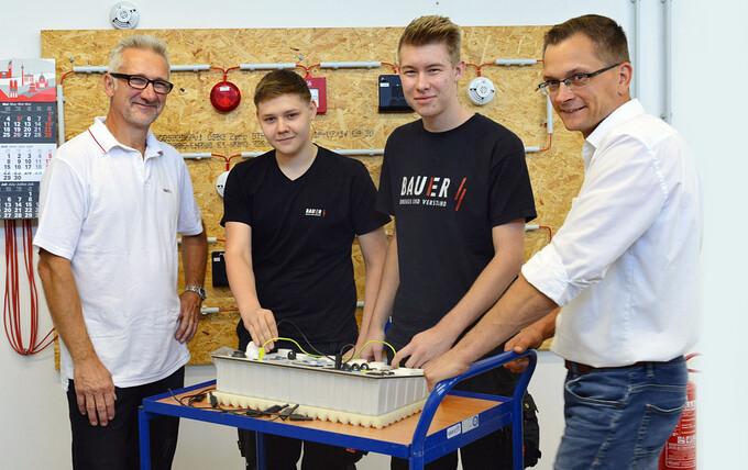 Instructor Olaf Wagner, the trainees Bastian Preuß and Florian Mohr and branch manager Dennis Ellwart