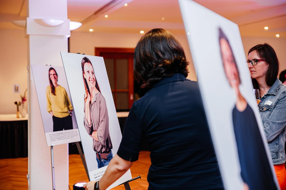 Besucherinnen schauen sich die Fotoausstellung an.