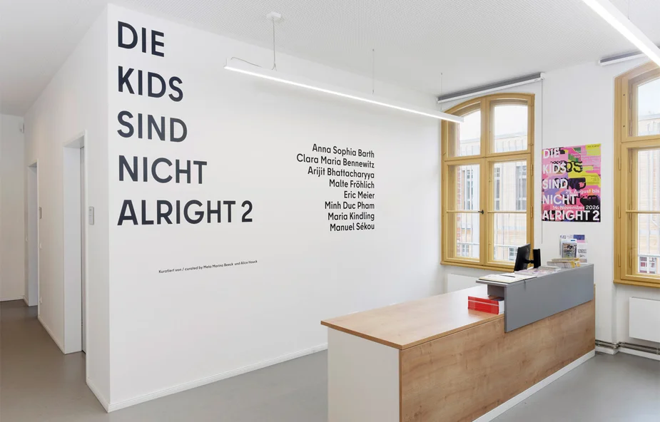 Ausstellungsraum mit Empfangstresen und Text an der Wand