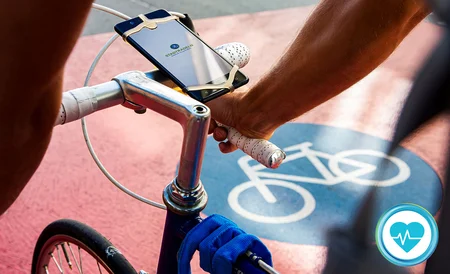 Blick eines Radfahrers von oben auf den Lenker eines Sportfahrrads. Auf dem Ashpalt ist eine Radwegmarkierung zusehen