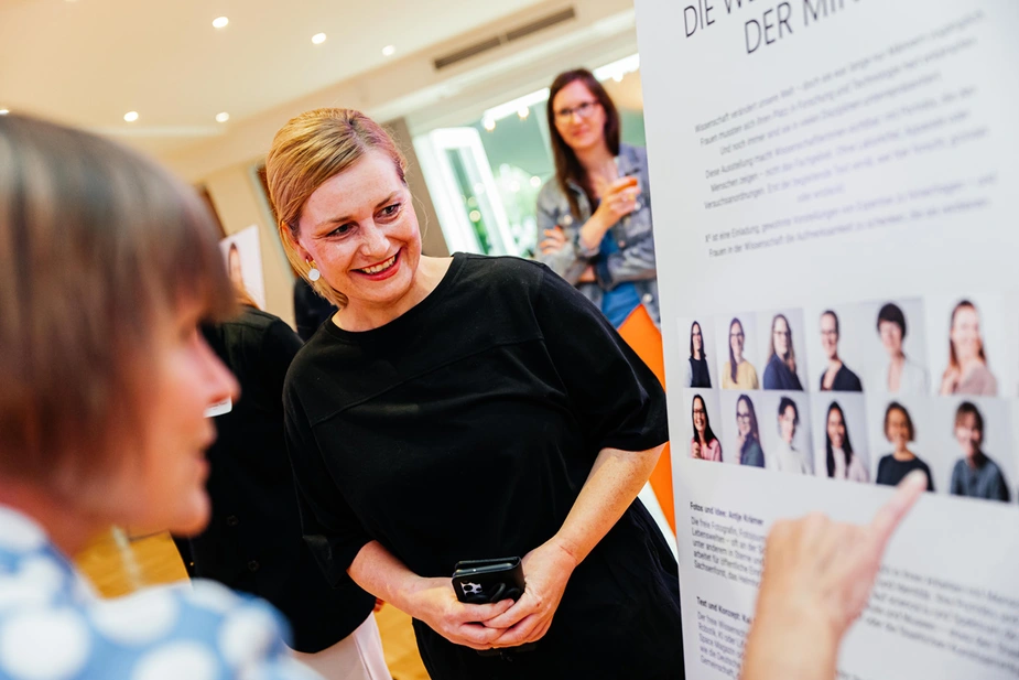 Besucherinnen schauen sich die Fotos an.
