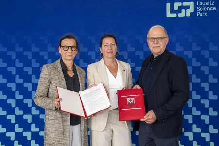 Drei Personen mit Vertragsunterlagen