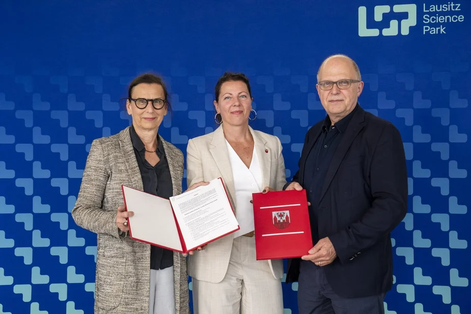 Drei Personen mit Vertragsunterlagen