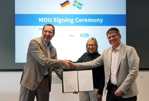 People shake hands, holding the contract in their hands.