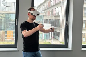 Mann mit einer VR-Brille auf dem Kopf und Steuerungsinstrumenten in den Händen