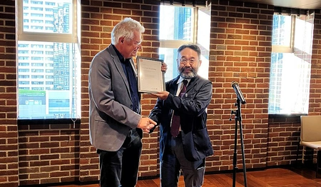 Two men in a room in front of a microphone