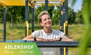 Frau lehnt an einer Metallstange auf einem Fitness-Platz im Freien