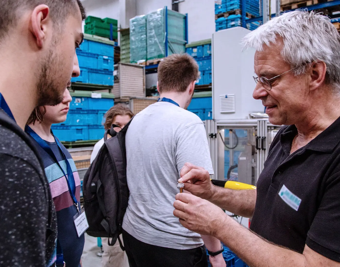 On an excursion to the training alliance: a teacher talking to a pupil. Other pupils stand in the background.