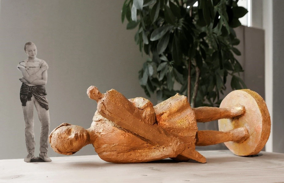 Skulptur eines auf der Seite liegenden Schulmädchens