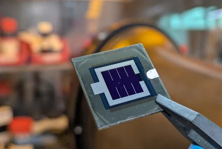 Tandemsolarzelle, die von einer Zange gehalten wird