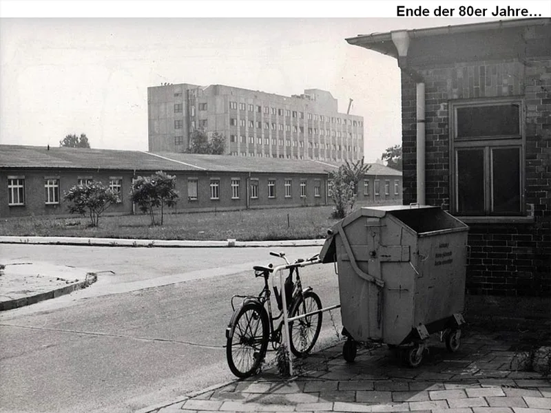 Gebäude, im Vordergrund eine Mülltonne und ein Fahrrad Ende der 1980er-Jahre