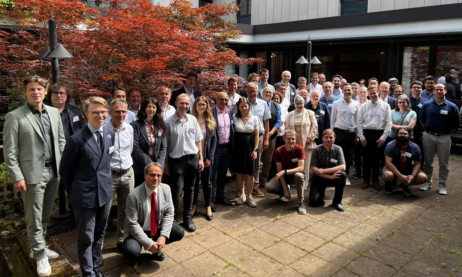 A group photo of about 60 people in front of a building.